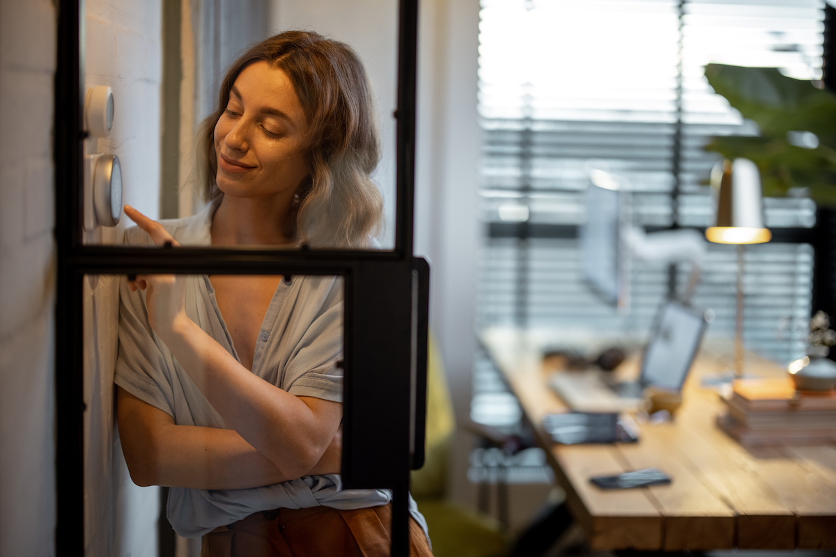 woman-controlling-smart-thermostat