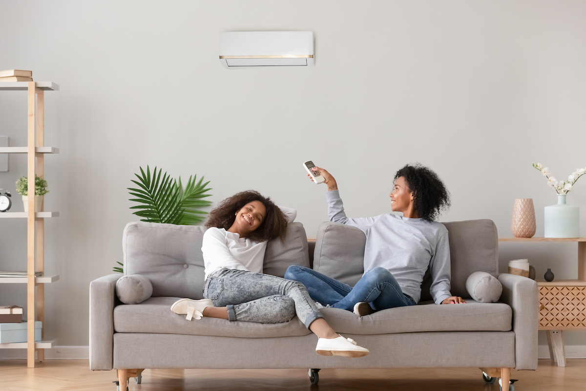 Woman Setting Air Conditioner with Remote